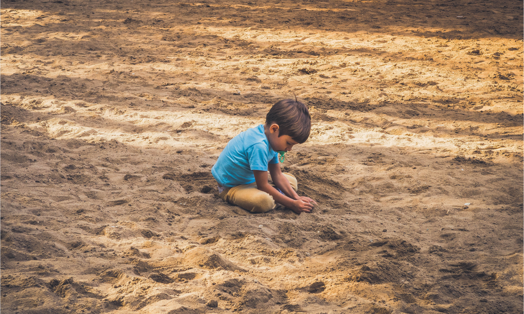 Kind Alleen in het zand